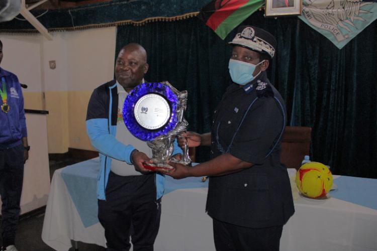 Deputy Inspector General responsible for Operations, Chalera, presenting a cup won by the Police Netball team