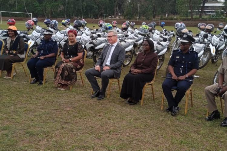 A group photograph in front of the donated motorcycles 